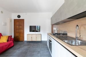 cocina con fregadero y sofá rojo en Minuetto Apartment - 2 bedrooms, en Vicenza
