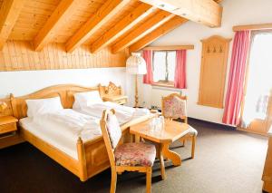 una camera da letto con un letto, un tavolo e delle sedie di Workation Apartments - 24-7 Self-Checkin - Hotel Postigliun Sedrun a Sedrun