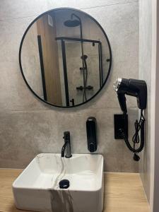 a bathroom sink with a mirror and a phone at Apartament Planeta 202 - tylko 100 m do plaży, odnowiony w 2024 in Mielno