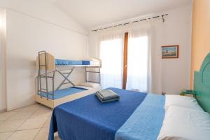 a bedroom with two bunk beds and a blue blanket at Le corti del turchese in Badesi