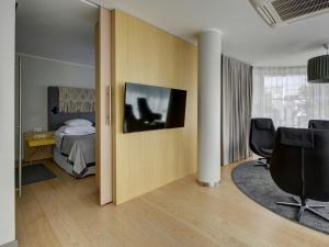 um quarto com uma cama e uma TV na parede em Estonia Resort Hotel & Spa em Pärnu