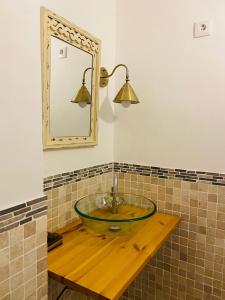 ein Badezimmer mit einem Glaswaschbecken und einem Spiegel in der Unterkunft VILLA FALI in Benaguacil