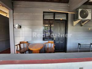 a table and chairs in front of a house at LestInn Homestay Monjali Mitra Reddoorz in Kejayan