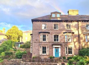 an old brick house with a rainbow in the sky at Tawny Roost in Buxton
