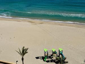 três cadeiras sentadas numa praia perto do oceano em Vistas al Mar, Piscina y Playa em Alicante