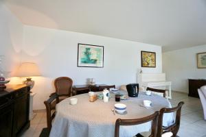 un comedor con una mesa con tazas y sillas en Les embruns *100m dela mer* parking*, en Ploemeur 26 fotos más