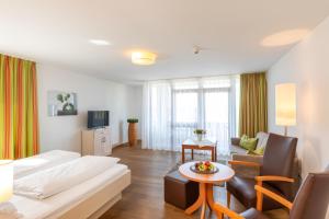 a hotel room with a bed and a living room at Landhotel Annelie in Preußisch Oldendorf