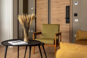 a living room with a chair and a table at Maison Bucarest Apartments by Olala Homes in Bucharest