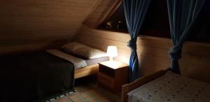 ein kleines Schlafzimmer mit einem Bett und einer Lampe in der Unterkunft Domki na Mazurach - Rybical 65 in Ryn