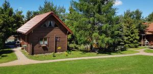 eine kleine Holzhütte in der Mitte eines Gartens in der Unterkunft Domki na Mazurach - Rybical 65 in Ryn