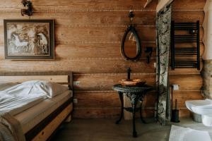 een slaapkamer met een bed, een spiegel en een wastafel bij Gordonówka Grand in Szaflary