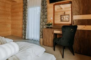 ein Schlafzimmer mit einem Schreibtisch und einem Stuhl neben einem Bett in der Unterkunft Gordonówka Grand in Szaflary