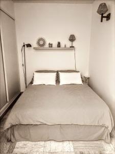 um quarto com uma cama grande e 2 almofadas em Appartement cosy centre ville em Sainte-Maxime