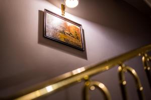 a picture hanging on a wall next to some stairs at Pod Ratuszem in Rzeszów