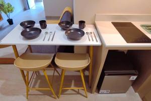 a kitchen table with bowls and utensils on it at Prime Location Gem Stylish 2BR at Menara Jakarta in Jakarta