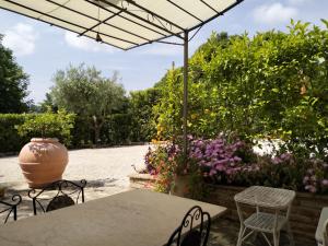 un patio con mesa, sillas y flores en Casa la Concia, en Potenza Picena