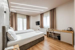 都拉斯Relax Inn Hotel Durres的有两张床和一张书桌的酒店房间
