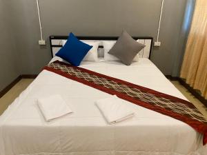 a bed with blue and white pillows on it at Saran Hostel krabi Thailand in Krabi town