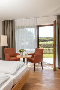 a bedroom with a bed and a table and chairs at Landhotel Annelie in Preußisch Oldendorf