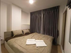 1 dormitorio con 1 cama con 2 toallas en J Condo rama 2, en Bangkok