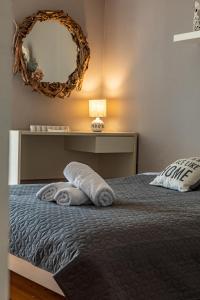 Schlafzimmer mit einem Bett mit einem Spiegel und Handtüchern in der Unterkunft Almyros Sea Front Villa in Myloi