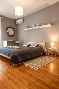um quarto com uma cama e um tapete num piso de madeira em Almyros Sea Front Villa em Míloi