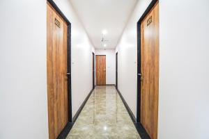 a corridor with two wooden doors and a tile floor at FabHotel Prime Palace View in Vadodara