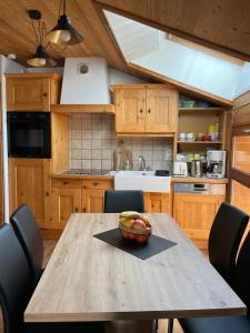 a kitchen with a table with a bowl of fruit on it at 40m2 au pied des pistes Hauteluce les saisies 4 à 6 personnes in Hauteluce