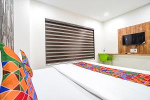 Zimmer mit einem Bett mit amerikanischer Flagge an der Wand in der Unterkunft FabHotel Prime Palace View in Vadodara