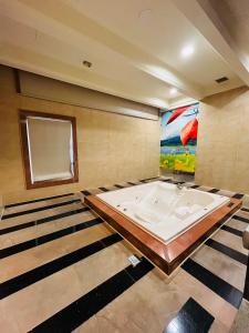 Walker Motel في تايبيه: حوض استحمام كبير في غرفة بها لوحة