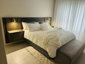 a bedroom with a large bed with white sheets and pillows at Luxury 3 Bedroom Apartment in Carlswald in Erand