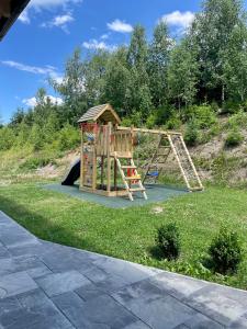 um parque infantil com escorrega e um baloiço em Zrubová chata Panorama Family em Habovka