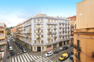 a large white building on a city street with cars at Comfortable apartment next to Apolo theater in Barcelona