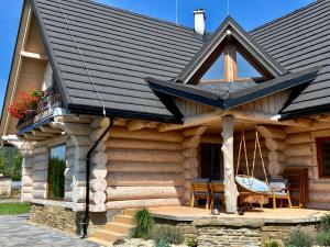 uma cabana de madeira com um telhado preto em Zrubová chata Panorama Family em Habovka