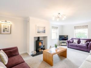 a living room with two purple couches and a fireplace at 5 Bed in Tealby 78678 in Tealby