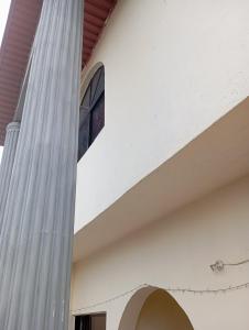 une colonne d'un bâtiment avec une fenêtre sur elle dans l'établissement Crale and Busino, à Port Harcourt