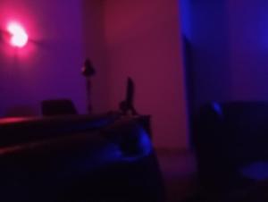 une chambre sombre avec une lumière rouge et bleue dans l'établissement Crale and Busino, à Port Harcourt