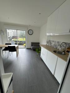 a kitchen and living room with a table and a clock at Studio indépendant et cosy in Basse-Goulaine +14 photos