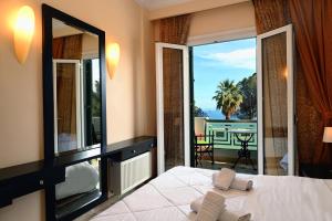 1 dormitorio con cama y espejo grande en Aktis Hotel, en Palaia Epidavros