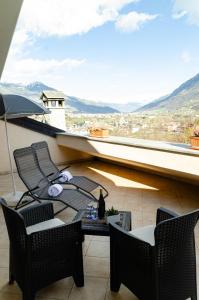 uma varanda com uma mesa e cadeiras e uma vista em Sarre Skyline Apartment - Relax in Valle d'Aosta em Aosta