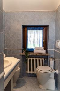uma casa de banho com um WC e uma janela em Sarre Skyline Apartment - Relax in Valle d'Aosta em Aosta