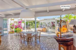 a dining room with a table and chairs and windows at La maison de Rosetta al mare in Specchiolla 