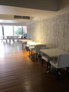 ein Esszimmer mit Tischen, Stühlen und einer Wand in der Unterkunft Un bonito lugar en el centro de Buenos Aires in Buenos Aires