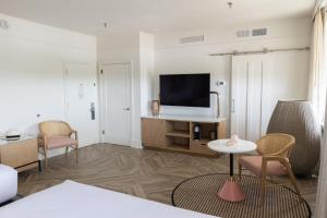 a living room with a tv and a table and chairs at La Concha Key West in Key West