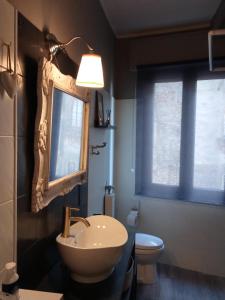 ein Badezimmer mit einem Waschbecken, einem Spiegel und einem WC in der Unterkunft COMECASADELUXE in Divignano