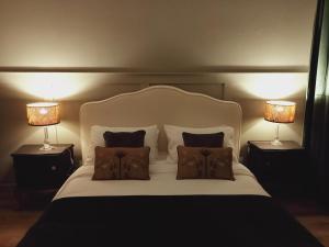 ein Schlafzimmer mit einem weißen Bett mit zwei Lampen in der Unterkunft COMECASADELUXE in Divignano