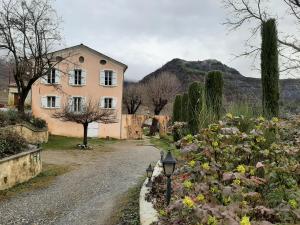 a house on a gravel road with flowers in front at Les gîtes du château in La Robine