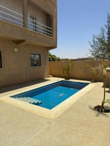 a swimming pool in front of a house at Grande Villa neuve 3 chambres avec piscine et wifi à Malikounda près Saly in Malikounda