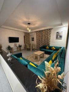 a living room with a blue couch and a tv at Appartements Guéliz Zerktouni in Marrakech
