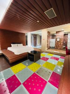 台北市にあるWalker Hotel - Chengdeのカラフルなフロアのベッドルーム1室(ベッド1台付)